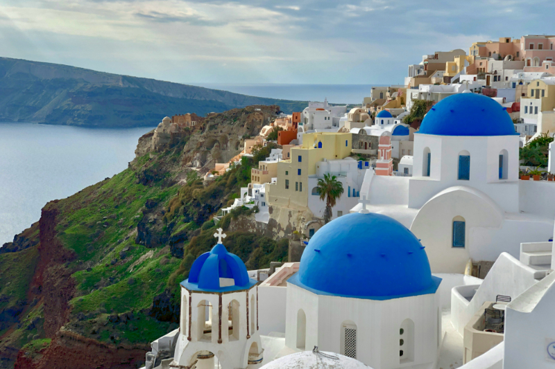 lick auf die ikonischen weiß-blauen Kuppeln von Santorini mit Blick auf das Ägäische Meer.