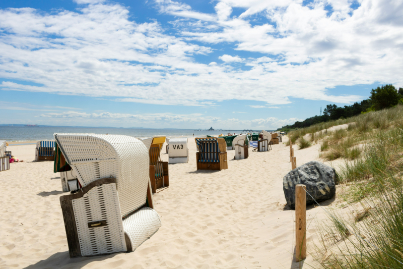 Weiße Sandstrände mit Strandkörben an der deutschen Ostseeküste bei Sonnenschein.
